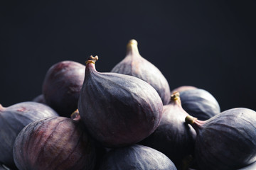 Fresh ripe figs against black background, closeup