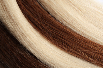Fototapeta premium Strands of different color hair as background, closeup