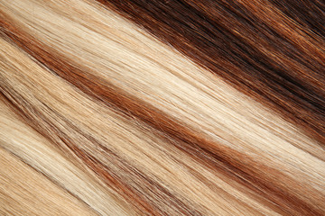 Naklejka premium Strands of different color hair as background, closeup