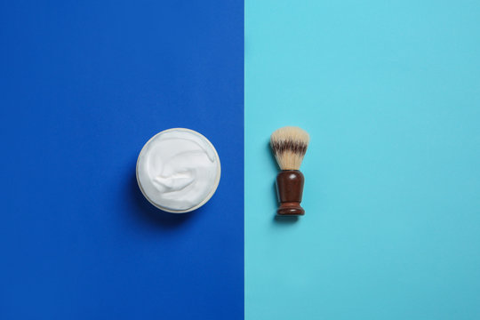Flat lay composition with shaving brush and cream on color background