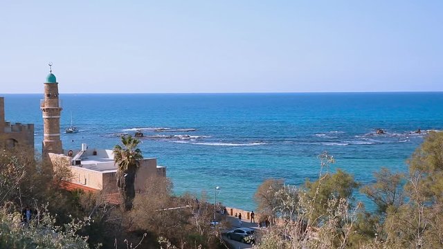 Big white yacht moving on Mediterranean sea behind minaret background