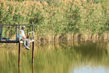 Fototapeta na wymiar Father and son fishing together on sunny day. Space for text