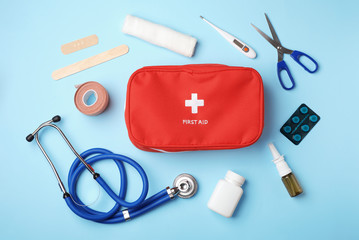Flat lay composition with first aid kit on color background