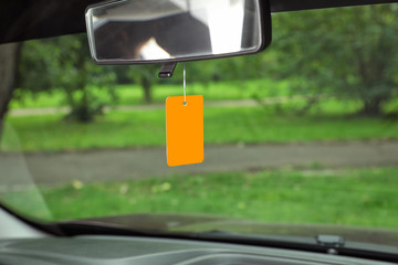 Air freshener hanging in car against windshield