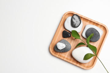 Plate with spa stones and space for text on white background, top view