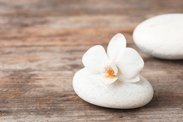 Fototapeta na wymiar Spa stone and orchid on wooden table