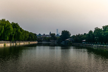 The old defense moat of the Forbidden City in Beijing with the modern skyscrapers in the background
