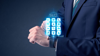 Businessman wearing smartwatch with application icons.