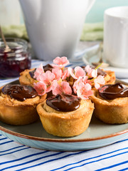 Cakes with frangipane, cherry jam and chocolate frosting. Romantic table setting with flowers. Mother's day card