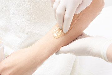 Unwanted hair wax epilation. Young Woman. cosmetology salon treatment procedure. Home waxing