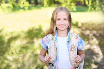 schoolchildren girl back to school. Happy girl smile with little backpack