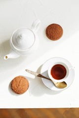 Breakfast on white table, tea and biscuits