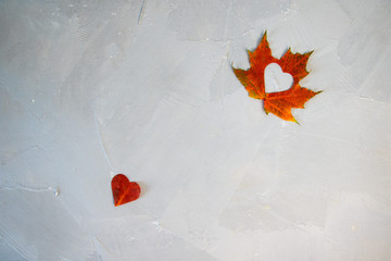 Autumn red and orange leaves with heart. Fall wooden background.