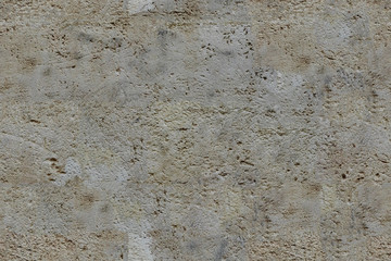 Background of old cracked light brown stone wall. seamless tiling texture