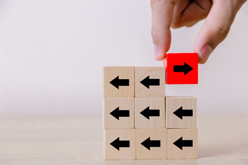 Red wooden blocks with black arrows facing opposite to the black arrows. With different concepts to...