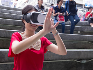 Visual reality concept.Young Asian woman using Visual reality or VR headset.Woman getting experience using VR-headset glasses.