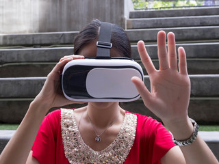 Visual reality concept.Young Asian woman using Visual reality or VR headset.Woman getting experience using VR-headset glasses.