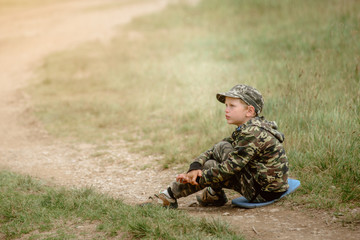 Boy sitting on grass and resting after hiking in Carpathian