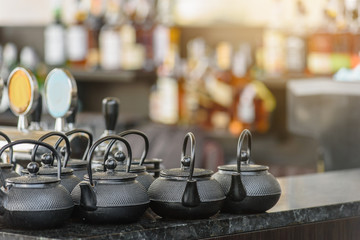 Herbal tea in teapots on bar counter in spa salon