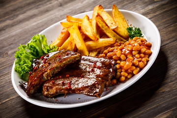 Tasty grilled ribs with french fries vegetables