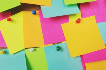 collection of colorful variety post it. paper note reminder sticky notes pin on cork bulletin...