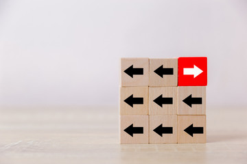 Red wooden blocks with white arrows facing opposite to the black arrows. With different concepts to...
