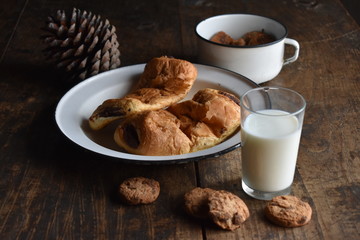 Plato con napolitanas de chocolate, galletas, vaso de leche