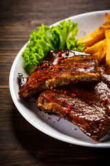 Tasty grilled ribs with french fries vegetables