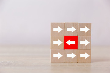 Red wooden blocks with white arrows facing opposite to the white arrows. With different concepts to...