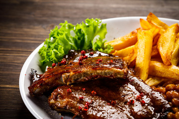 Tasty grilled ribs with french fries vegetables