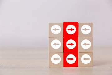 Red wooden blocks with white arrows facing opposite to the white arrows. With different concepts to...