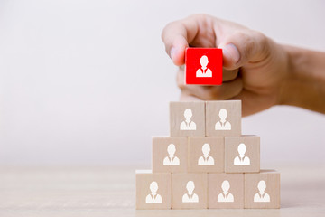 Hand putting wood cube block on top pyramid,human resource management and recruitment business concept, Business Strategy to success.