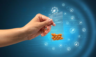 Hand delivers colorful pills in small plastic bag with medicine concept