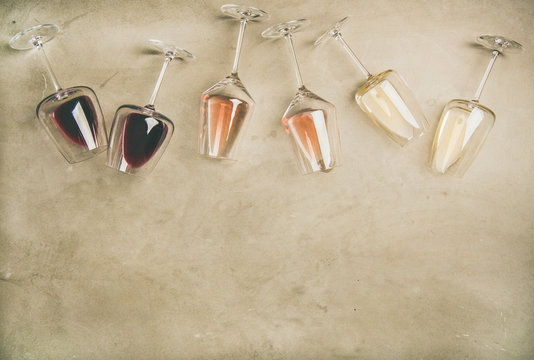 Fototapeta Flat-lay of red, rose and white wine in glasses and corkscrews over grey concrete background, top view, copy space. Wine bar, winery, wine degustation concept