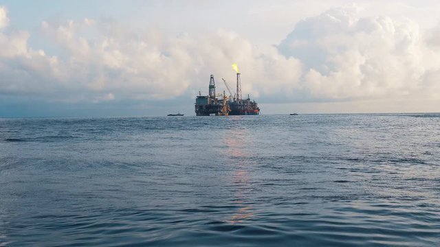 FPSO tanker vessel near Oil Rig platform. Offshore oil and gas industry. Flare is burning with smoke. Environmental pollution