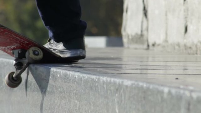 Skateboarder does the grind trick crooked on granit ledge on memorial