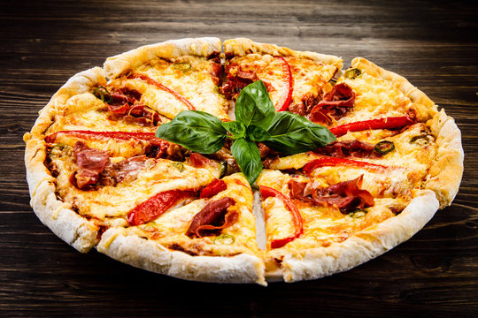 Pizza with ham and pepper on wooden table