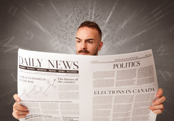 Young smart businessman reading daily newspaper with alphabet letters above his head