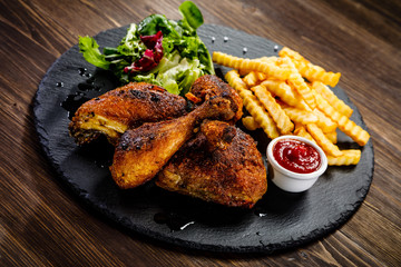 Grilled chicken legs with french fries and vegetables