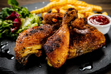 Grilled chicken legs with french fries and vegetables