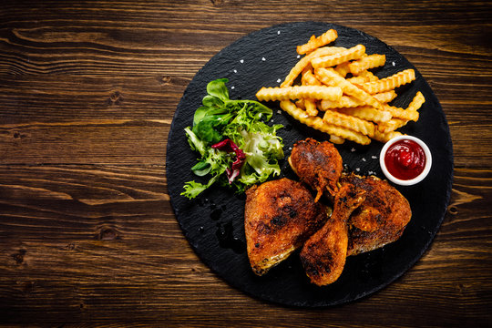 Grilled chicken legs with french fries and vegetables