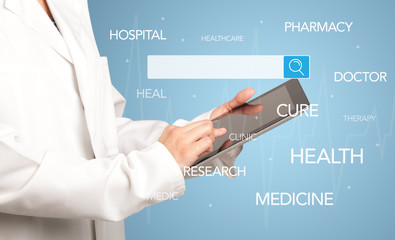 Fototapeta na wymiar Female doctor holding tablet with blue background and search bar with hovering medical words