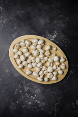 Champions mushrooms on wood board at black background