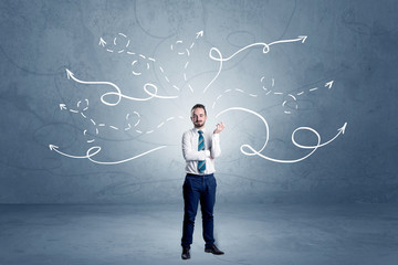Elegant businessman choosing between directions with winding drawn arrows around 

