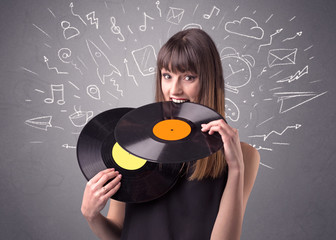 Young lady holding vinyl record on a grey background with mixed scribbles behind her