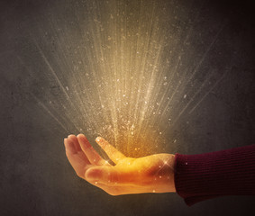 Yellow ray of light coming from a young hand 