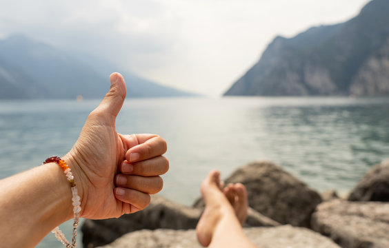 Close Up Of Woman Hand Thumb Up Happy And Relax By A Beautiful Big Lake