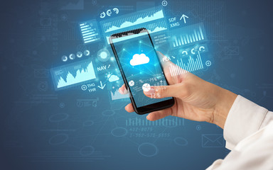 Female hand using smartphone with financial tracking concept illustrated by graphs and symbols
