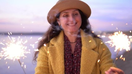 The woman by the sea looks at a festive feyerferk. Bengal light. Beach.