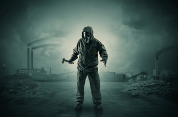 Gas masked survival man coming with arms on his hand  in a demolished dark environment 
